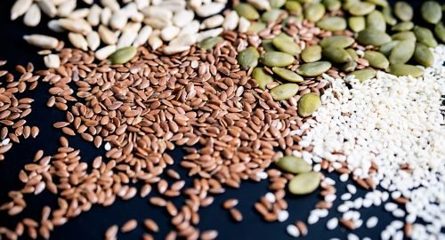 Various seed on the black. Flax, sesame, sunflower and pumpkin seed, close up.